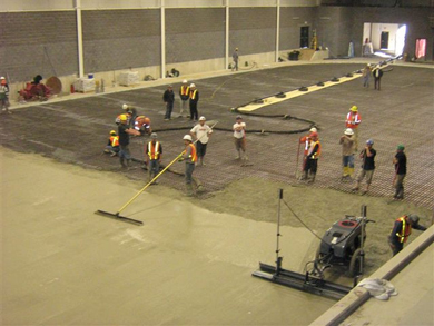 Construction workers lay concrete across the complex's interior floor
