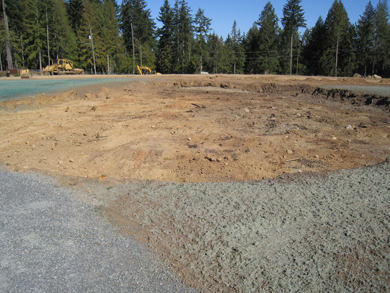 Excavated earth flanked by a gravel path and freshly seeded areas