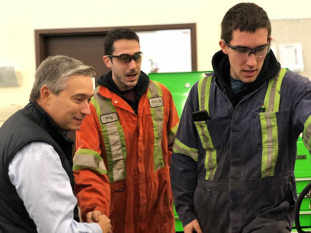 Minister Champagne speaking with two tradepeople