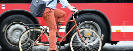 Person riding a bike beside a bus