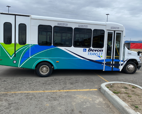 Parked bus with green blue and white colors.