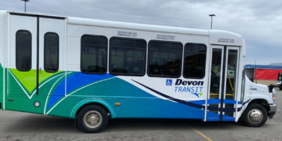 Parked bus with green blue and white colors.