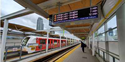 A modern, red and white high-speed passenger train is stationed at a covered outdoor platform of a train station.