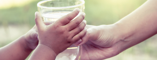 Hands holding a glass of water 