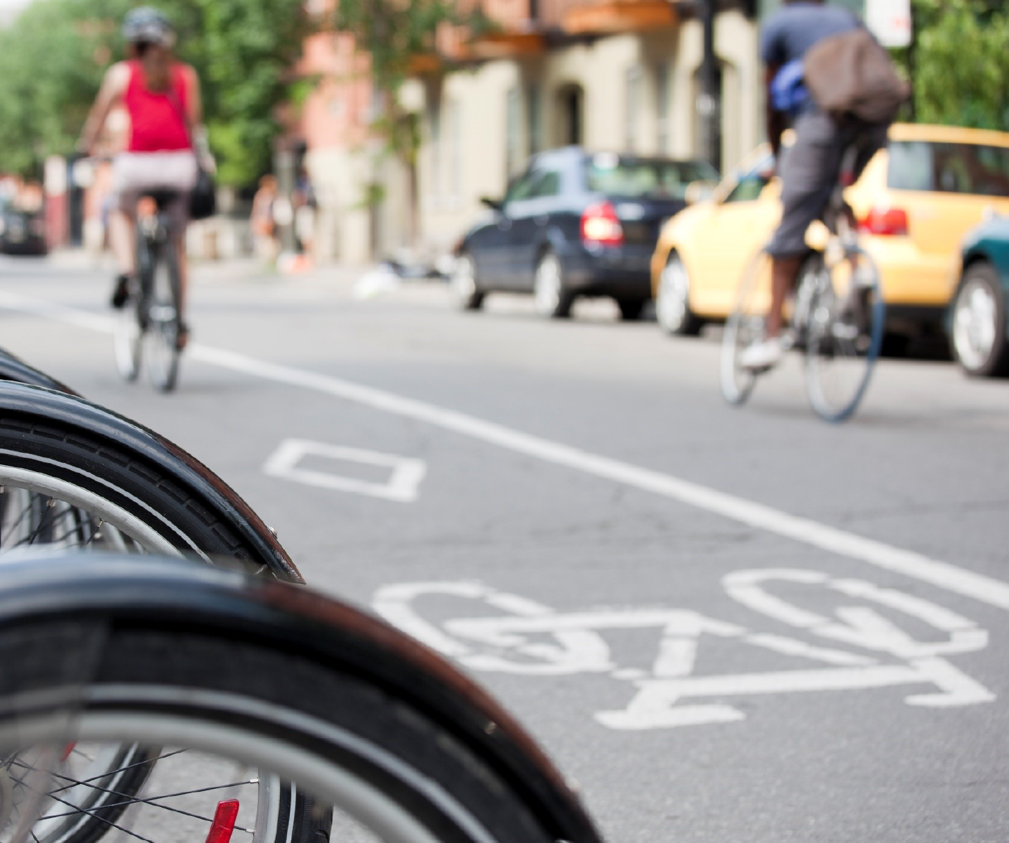 Public bike-sharing system with two bicycle rider commuters riding in the background. 