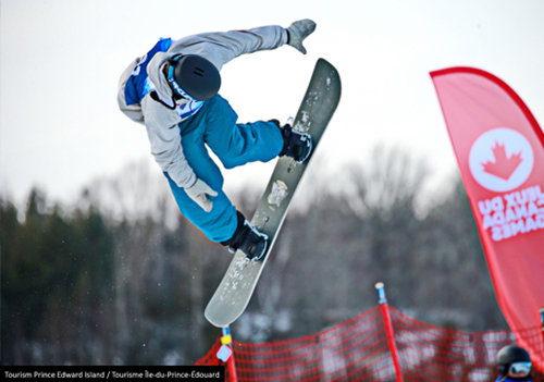 Snowboarder in mid-air as they perform a jump trick