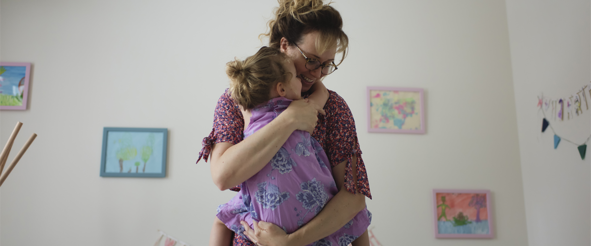 A parent holding their child in their arms.