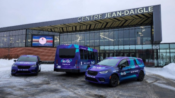 Three purple and blue vehicles, including a car on the left, a small bus in the middle and a minivan on the right, parked in front of a glass two-storey building.
