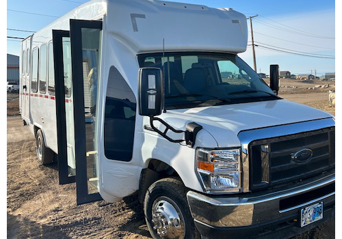 A white bus in a parking lot.